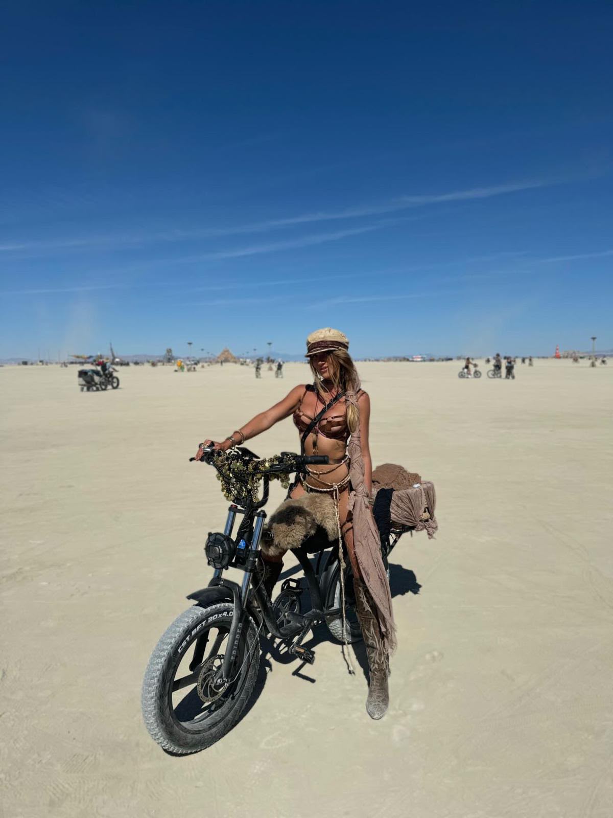 Burner biking across Black Rock City in handmade Vista Collective pieces